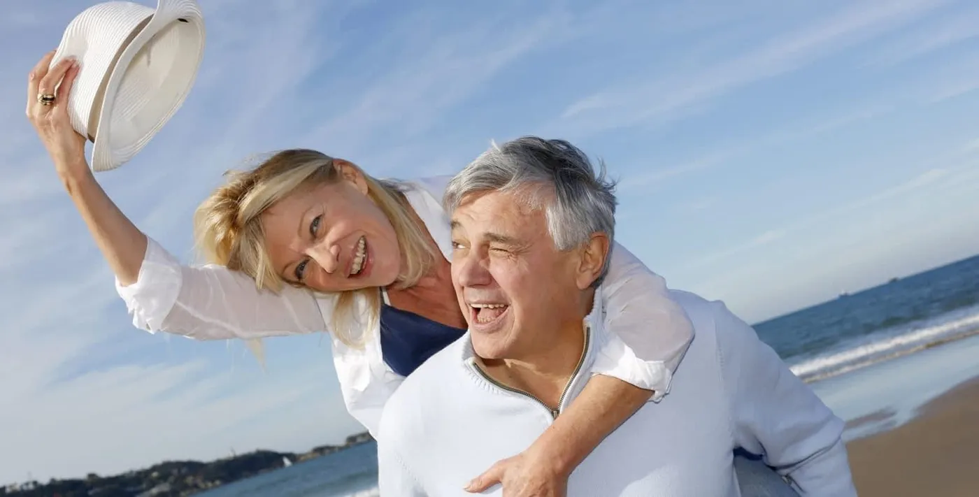 Couple heureux riant ensemble au bord de la mer